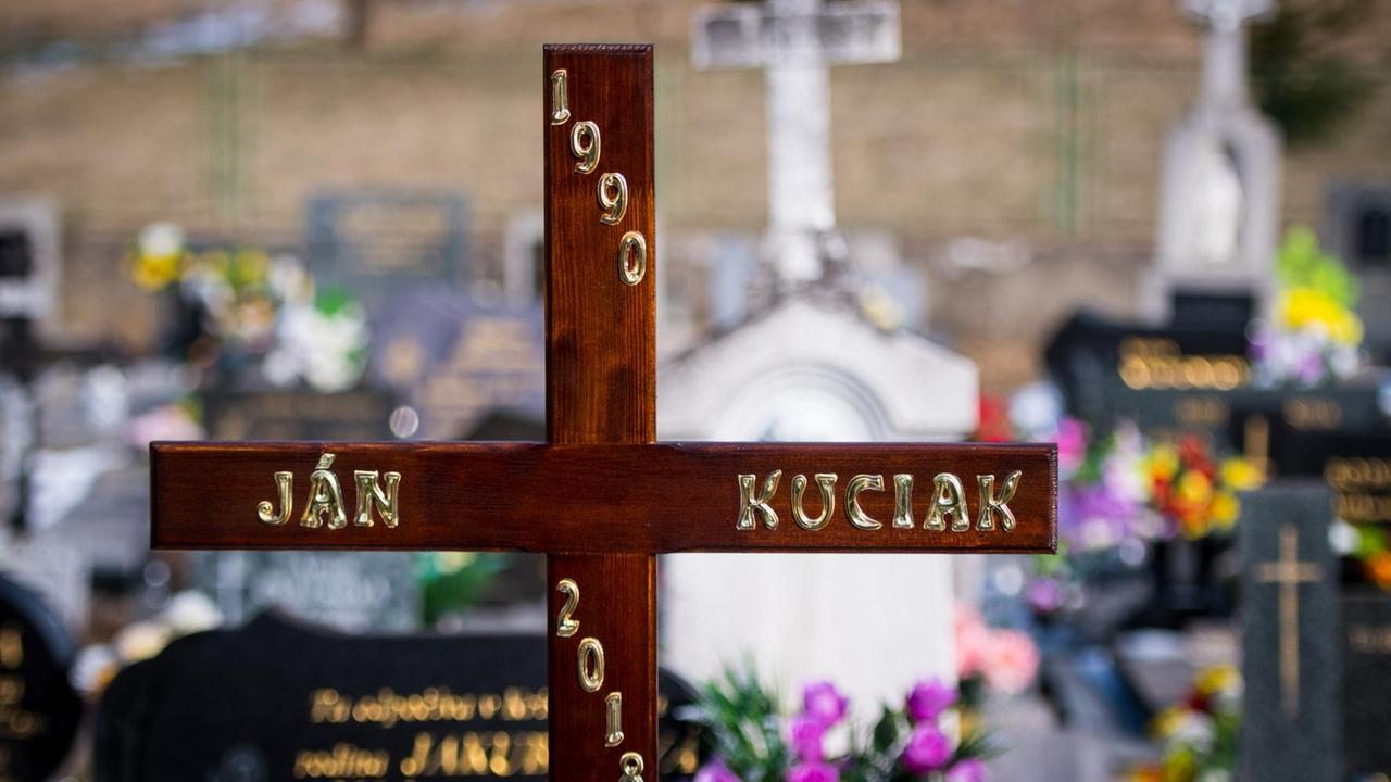A cross stands on the grave of murdered journalist Jan Kuciak, who was slain as he was about to publish an explosive report on alleged high-level corruption linked to the Italian mafia, prior to his funeral at a cemetery in Stiavnik, Slovakia, on March 3, 2018.
Kuciak was found shot dead on February 25, 2018 as he was about to publish an article that raised possible political links to Italian businessmen operating in Slovakia with alleged ties to Calabria's notorious 'Ndrangheta mafia. / AFP PHOTO / VLADIMIR SIMICEK
