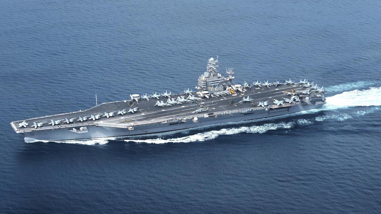 Luftbild des Schiffes im Meer mit zahlreichen Kampfjets an Bord.