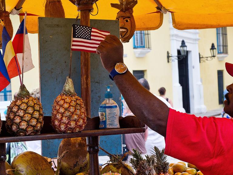 Ein Obst-Verkäufter in Kuba dekoriert seinen Stand mit einer US-Flagge.