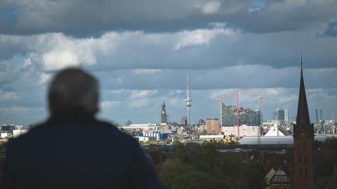 Ein Mann schaut am 24.10.2013 vom Dach des Energiebunkers auf die Skyline von Hamburg, die Elbphilharmonie (r-l), den Heinrich-Hertz-Turm und die Michaelis Kirche