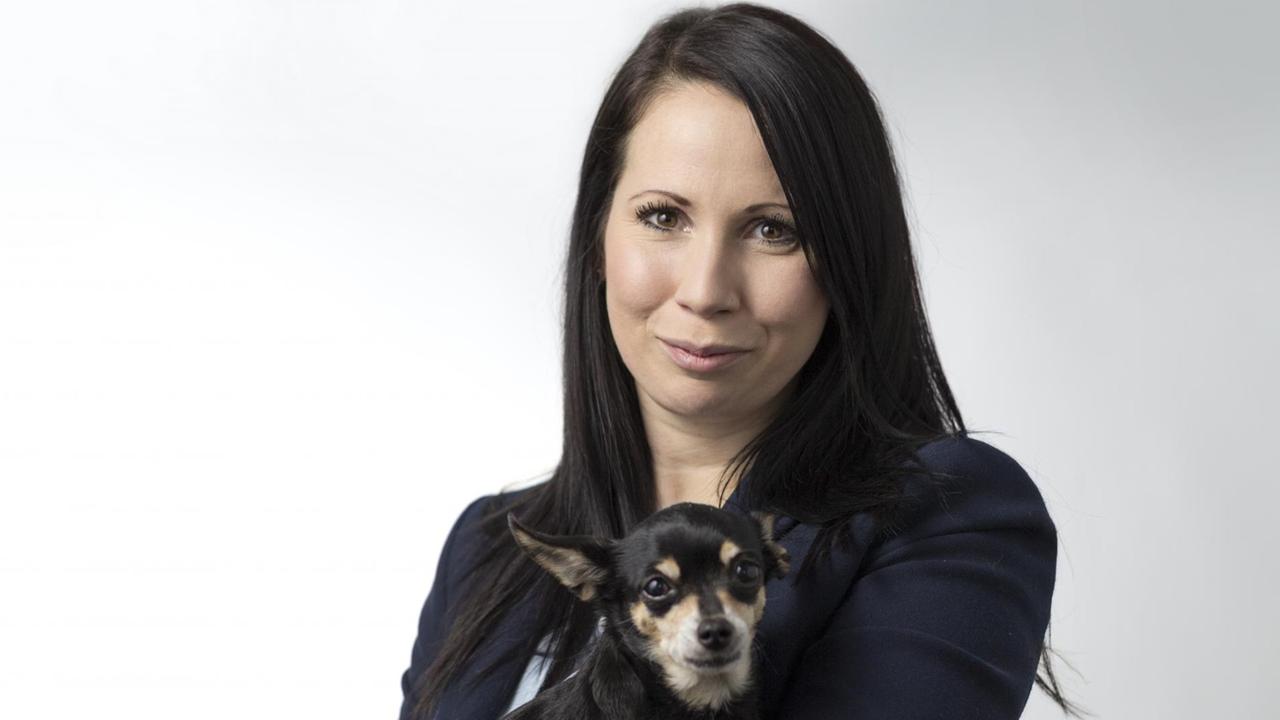 Jana Hoger, Referentin "Tierische Mitbewohner" bei der Tierrechtsorganisation PETA Deutschland e.V. mit einem kleinen Hund auf dem Arm