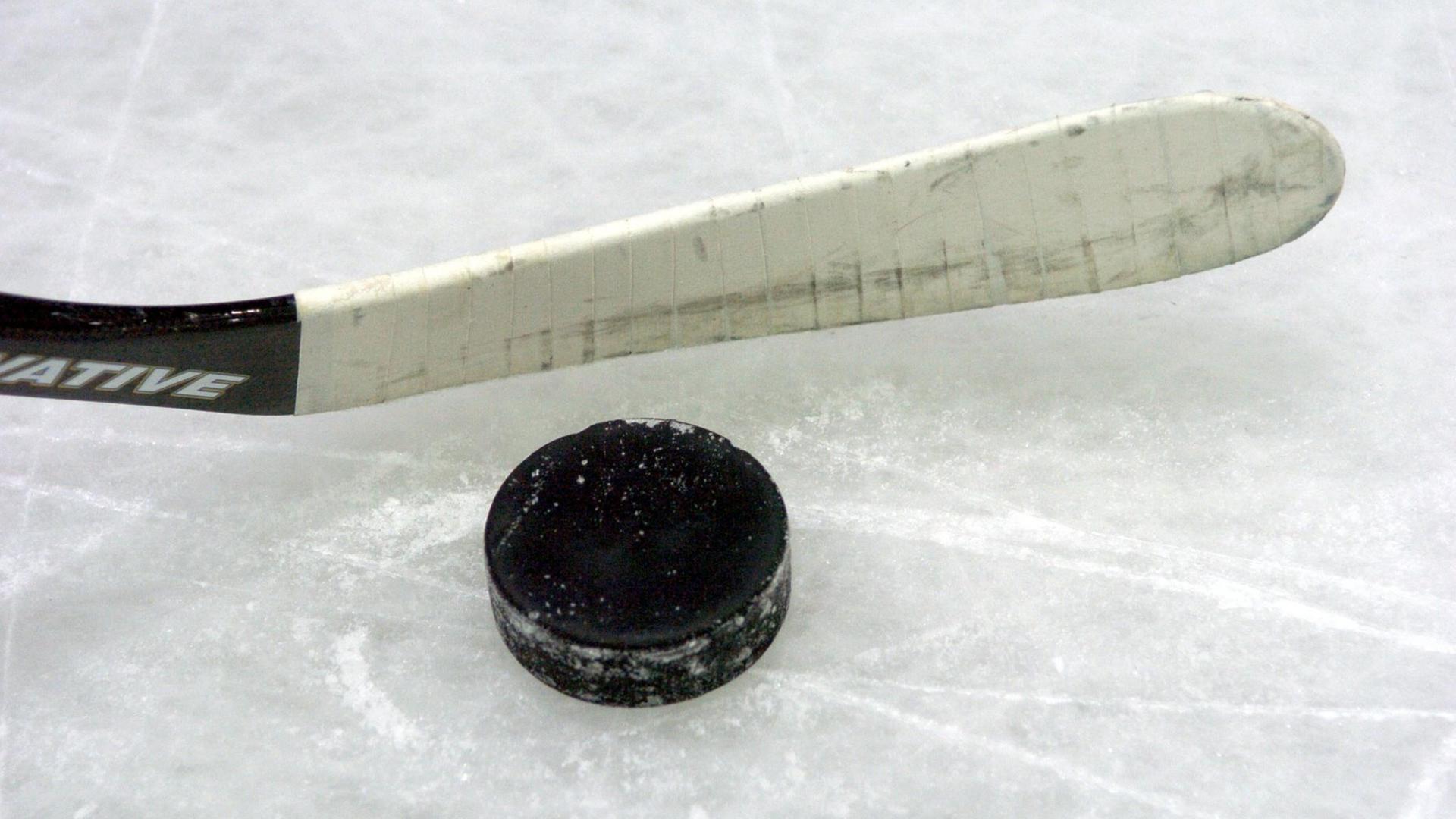 Ein Eishockey-Schläger mit einem Puck.
