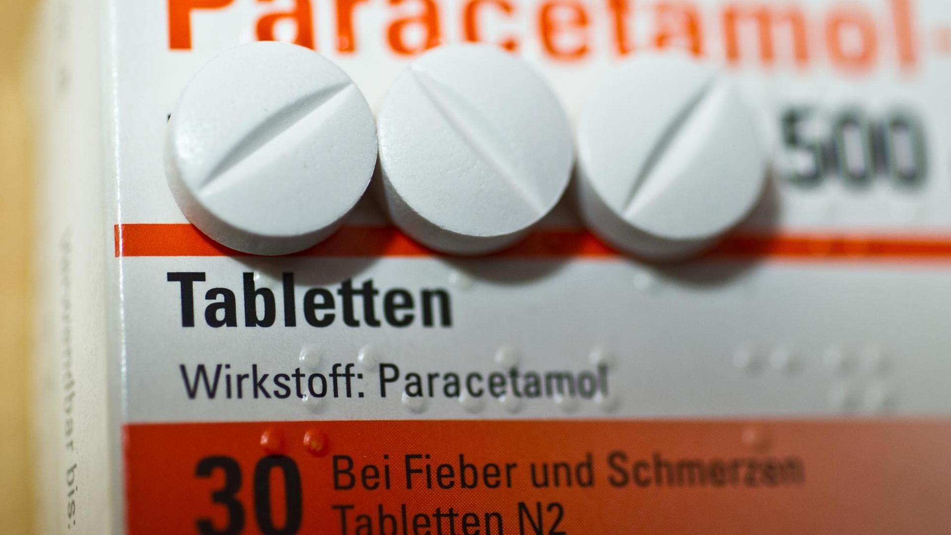 Auf einer Arzneiverpackung liegen Tabletten, die den Wirkstoff Paracetamol enthalten.