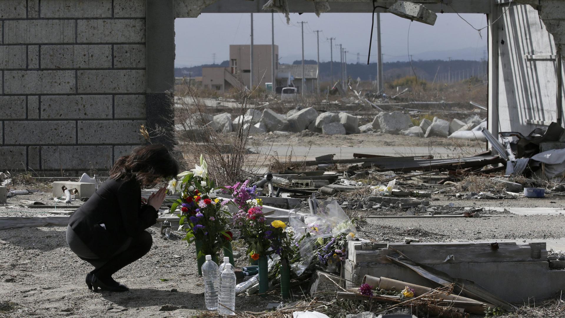 11. März 2015: Am vierten Jahrestag erinnert eine Frau in Fukushima mit Blumen an die Reaktorkatastrophe.