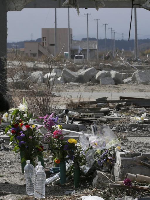 Am vierten Jahrestag erinnert eine Frau in Fukushima mit Blumen an die Reaktorkatastrophe.