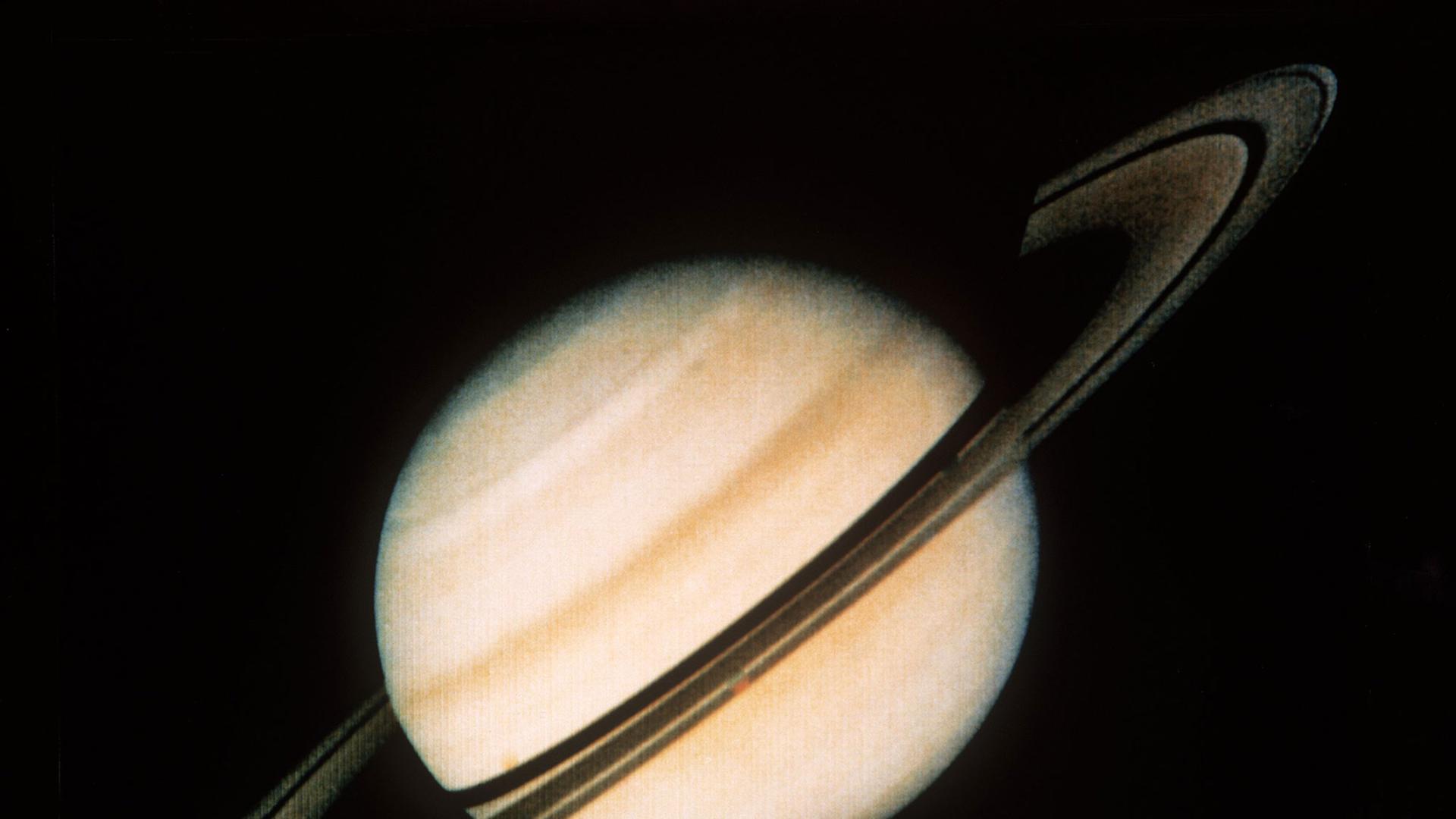 Eine Aufnahme des Saturns mit seinen Ringen und dem Mond Dione (unten, roter Punkt) aus 34 Millionen Kilometern Entfernung, die von der Raumsonde Voyager 1 am 18. Oktober 1980 der US-Raumfahrtbehörde NASA übermittelt wurde. Eine Aufnahme des Saturns mit seinen Ringen und dem Mond Dione (unten, roter Punkt) aus 34 Millionen Kilometern Entfernung, die von der Raumsonde Voyager 1 am 18. Oktober 1980 der US-Raumfahrtbehörde NASA übermittelt wurde.