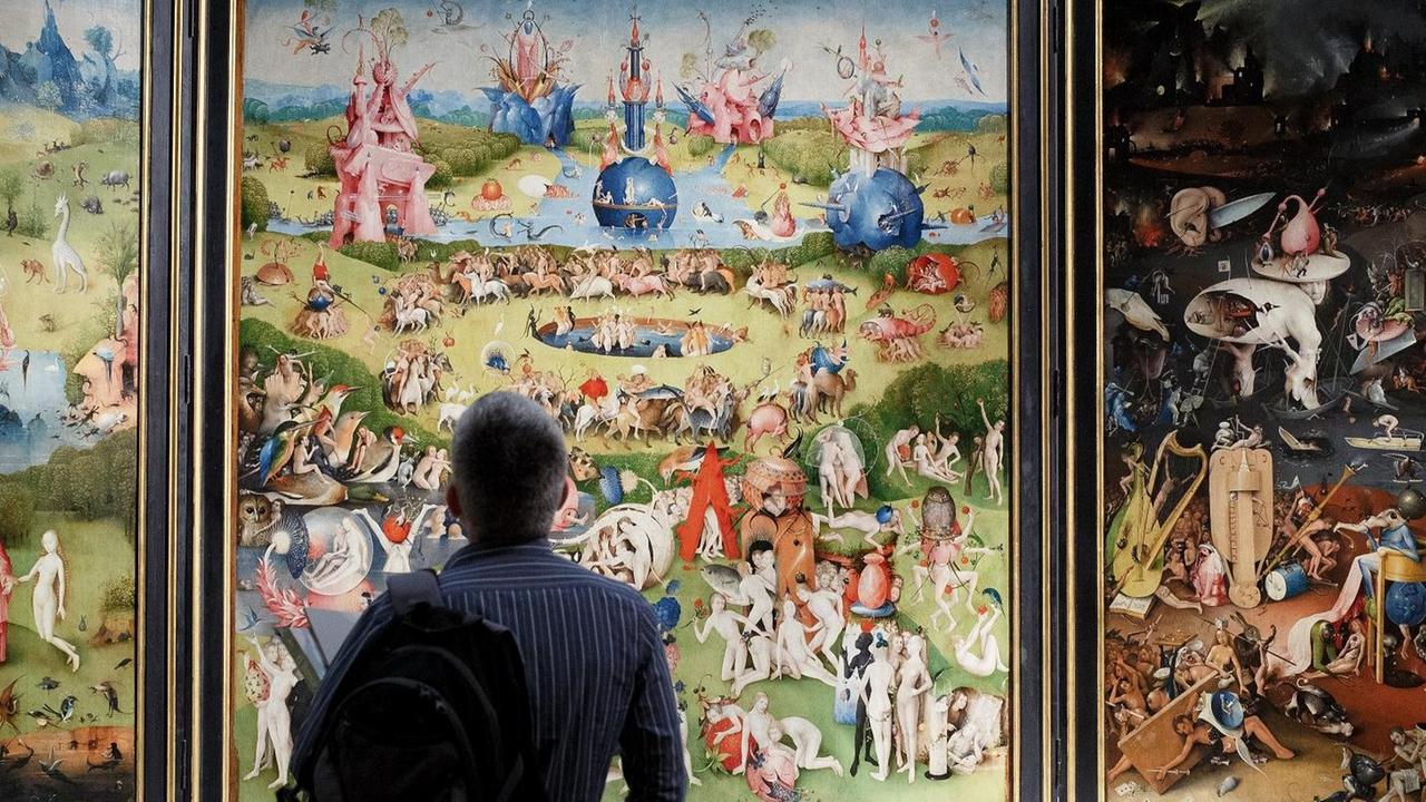 Ein Mann betrachtet Hieronymus Boschs Tryptichon "Garten der Lüste".