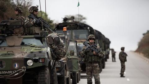 Ein Konvoi der französischen Armee steht auf einer Straße in der Zentralafrikanischen Republik. Die Soldaten tragen Waffen.