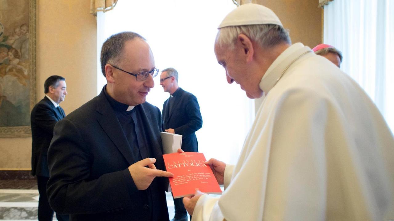 Der Theologe und Journalist Antonio Spadaro überreicht Papst Franziskus eine Ausgabe der Jesuitenzeitschrift "Civiltà Cattolica". Die Zeitschrift wird zunehmend als Sprachrohr des Papstes verstanden.