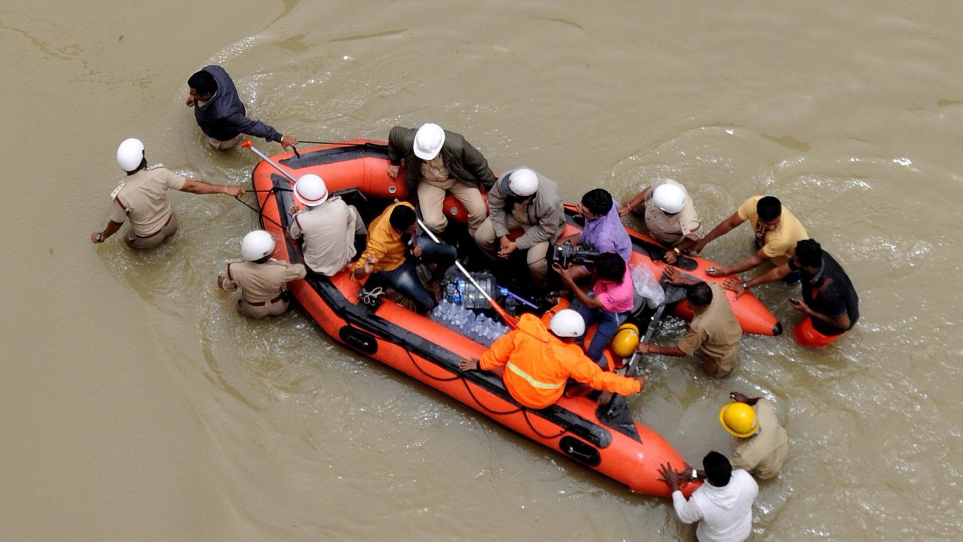 Bengaluru, Indien: Menschen versuchen, sich in einem Schlauchboot vor den Fluten zu retten. Bengaluru, Indien: Menschen versuchen, sich in einem Schlauchboot vor den Fluten zu retten.