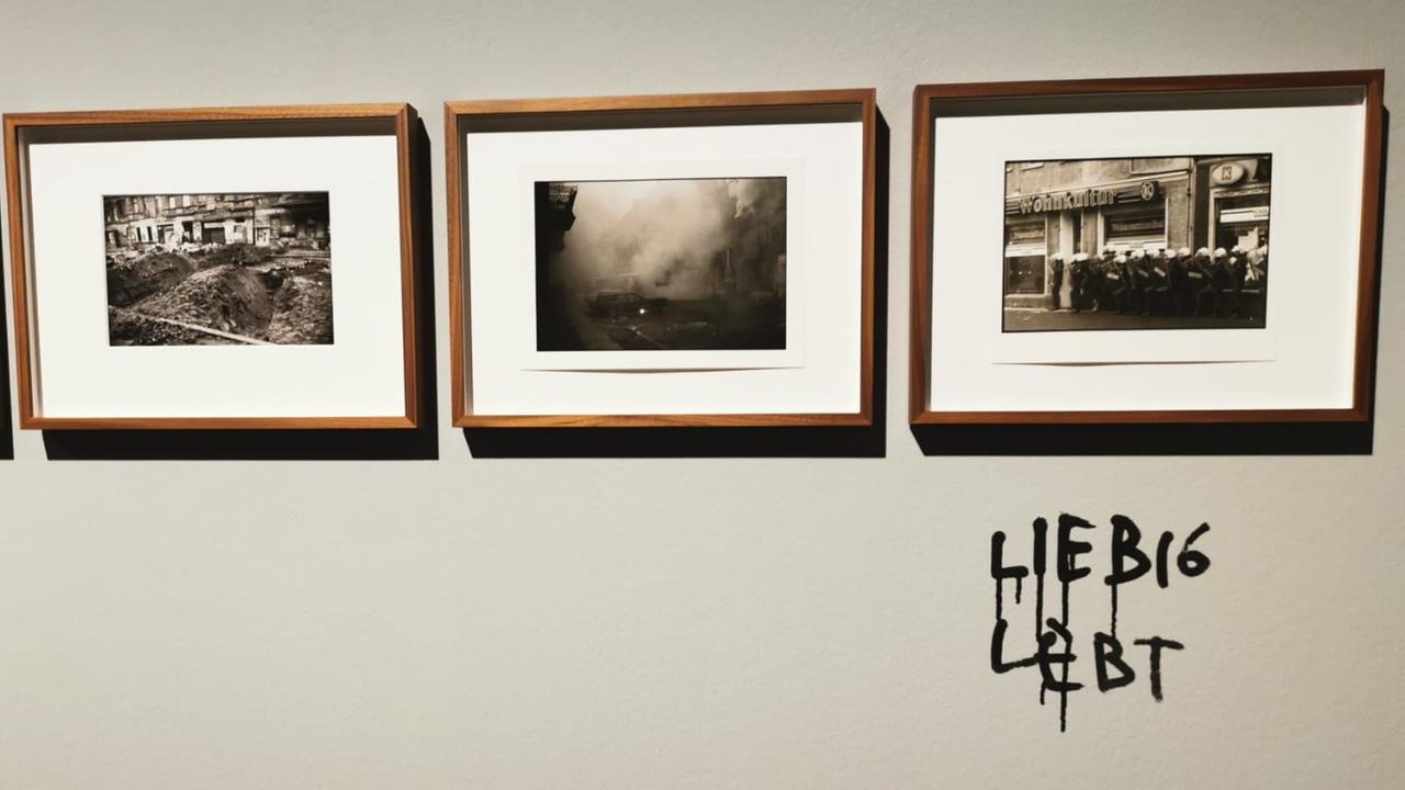 Drei gerahmte schwarz-weiß Fotografien, darunter ein mit Edding gemalter Schriftzug "Liebig lebt"