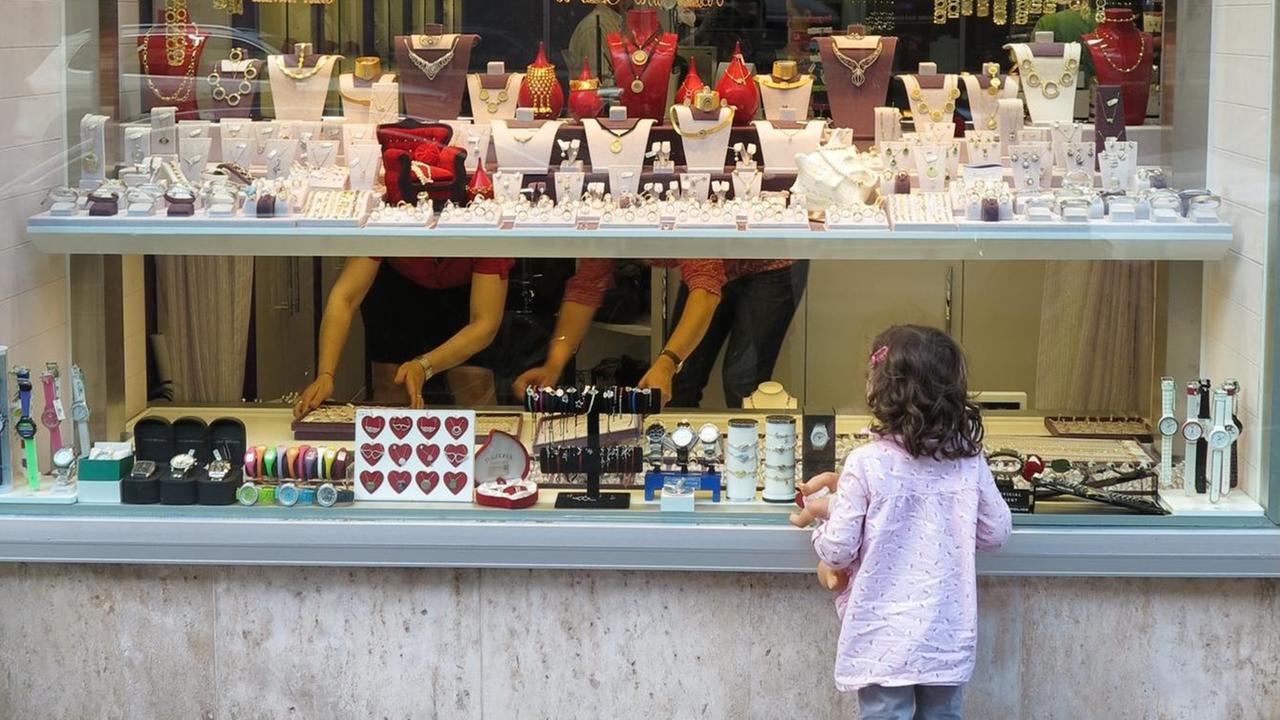Ein Mädchen schaut in die Auslage eines Juweliergeschäftes in München
