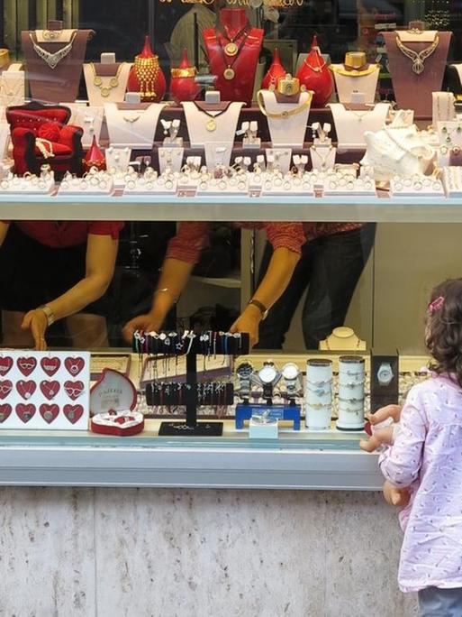 Ein Mädchen schaut in die Auslage eines Juweliergeschäftes in München