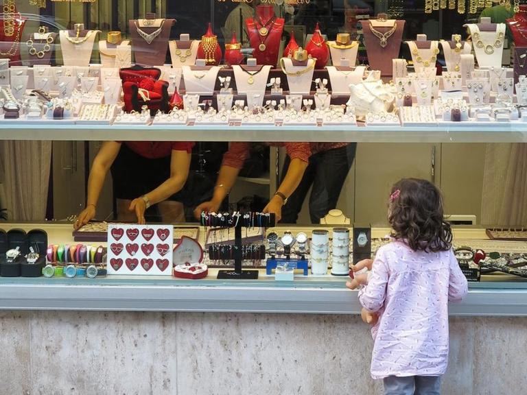 Ein Mädchen schaut in die Auslage eines Juweliergeschäftes in München
