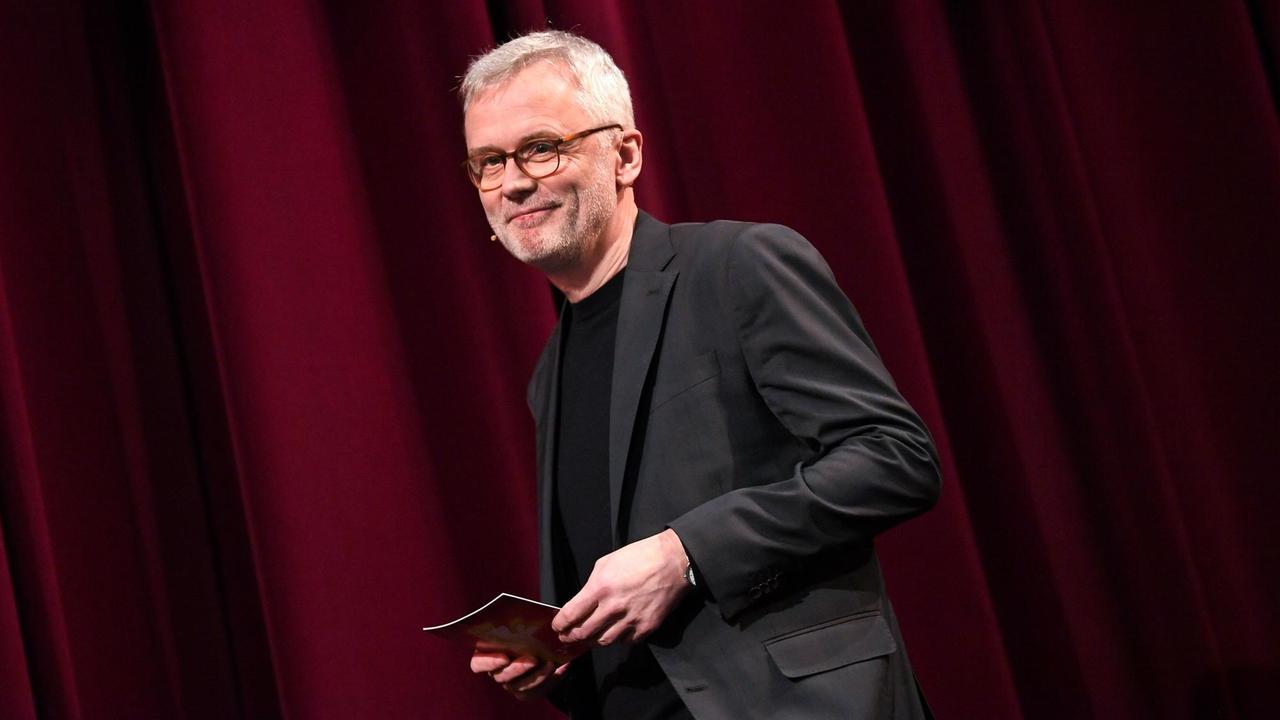 Christoph Terhechte steht auf der Bühne der Berlinale. Er trägt ein schwarzes Sakko und schaut freundlich in das Publikum.