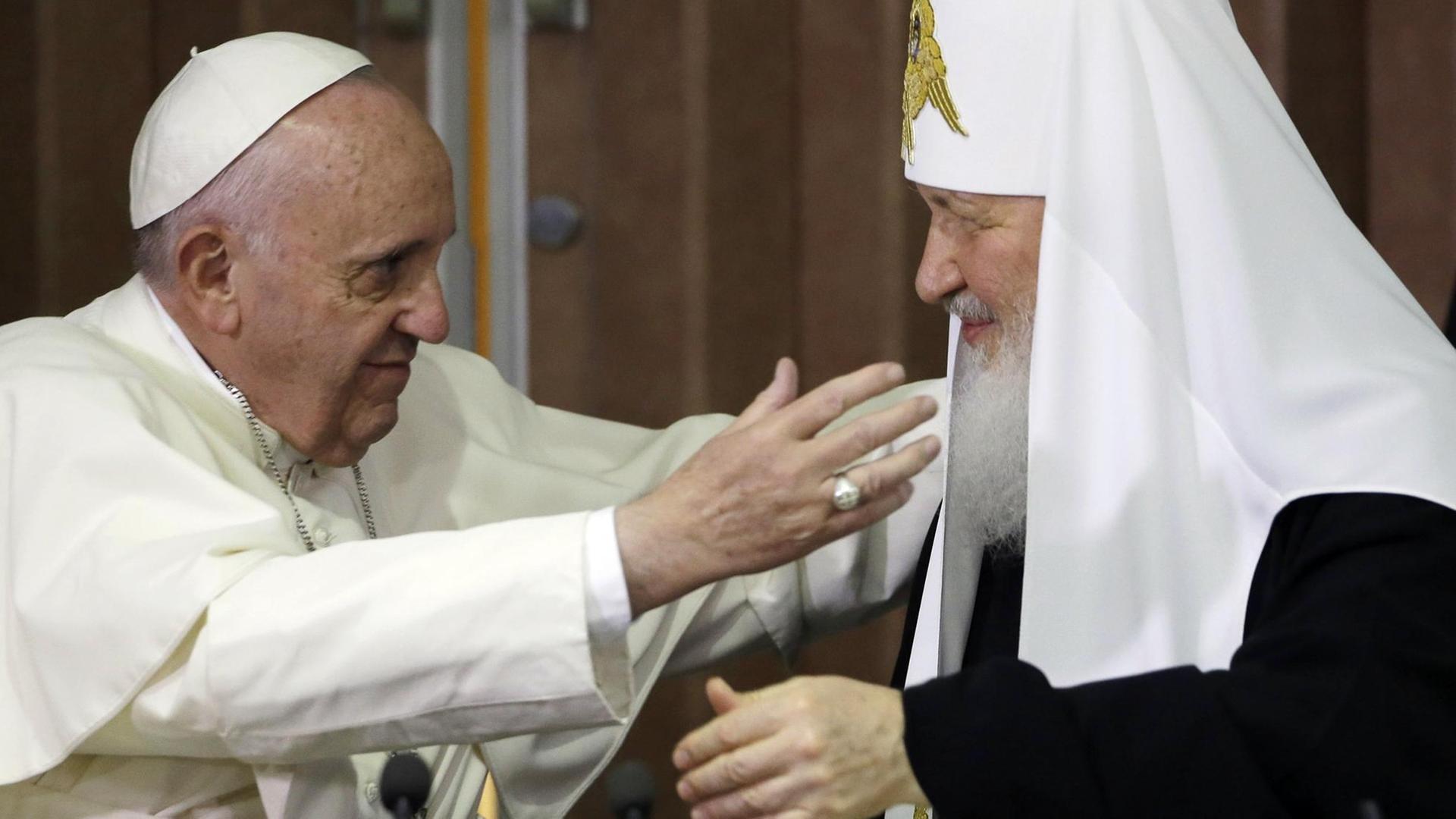 Papst Franziskus und Patriarch Kyrill wollen sich umarmen.