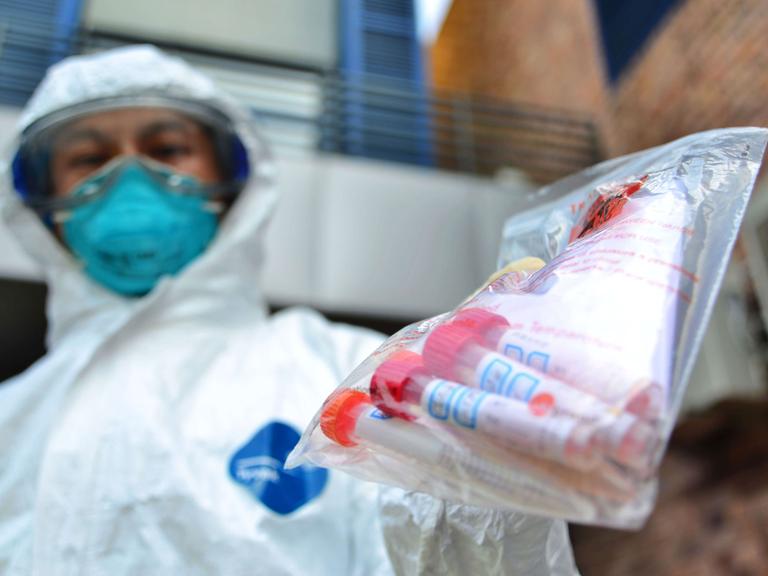 Ein Mitglied der Hongkou District Center for Disease Control & Prevention hat einen Beutel mit Proben des Vogelgrippevirus H7N9 in der Hand