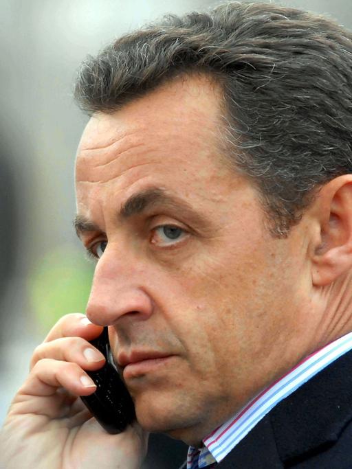 Nicolas Sarkozy telefoniert mit einem Handy