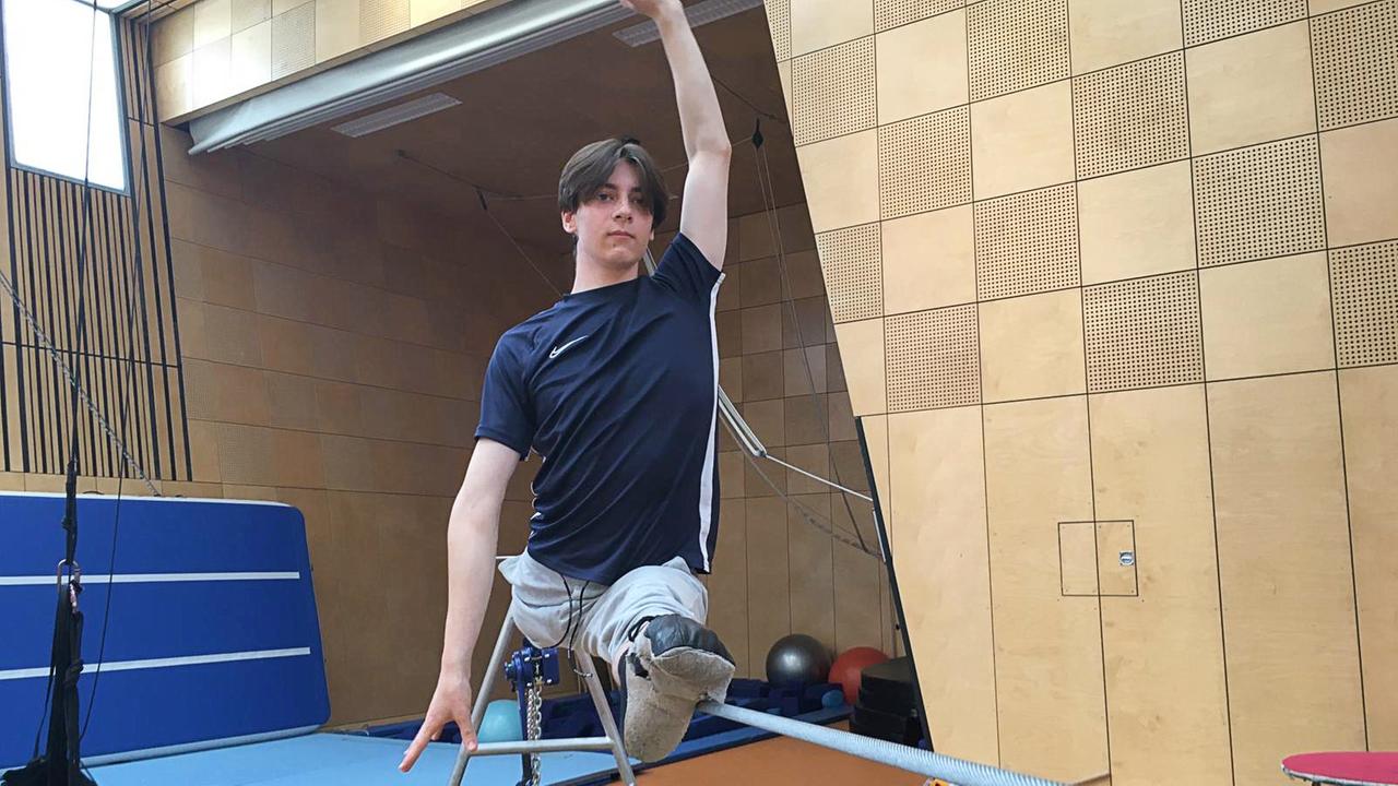 Ein junger Mann balanciert auf einem Seil in der Trainingshalle der Staatlichen Artistenschule Berlin.