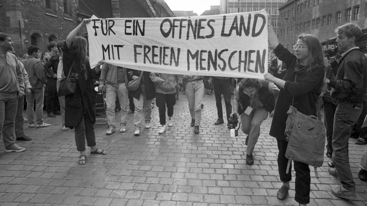 DDR-Bürger demonstrieren am Abend des 4.9.1989 in der Innenstadt von Leipzig für Reisefreiheit und Reformen. Einige Demonstranten tragen ein Transparent mit der Aufschrift "Für ein offenes Land mit freien Menschen".