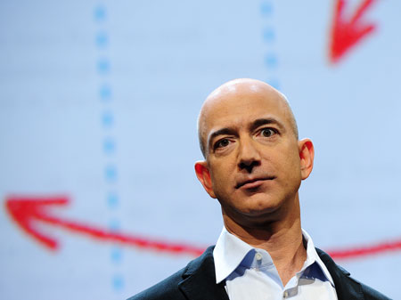 Portraitfoto: Amazon-Gründer und -Präsident Jeff Bezos steht vor einer Videowand auf der gezeichnete Pfeile zu sehen sind.