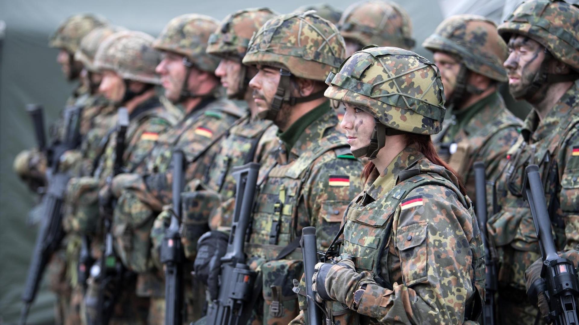 Eine deutsche Bundeswehr-Soldatin mit ihren Kameraden auf einem Militärstützpunkt