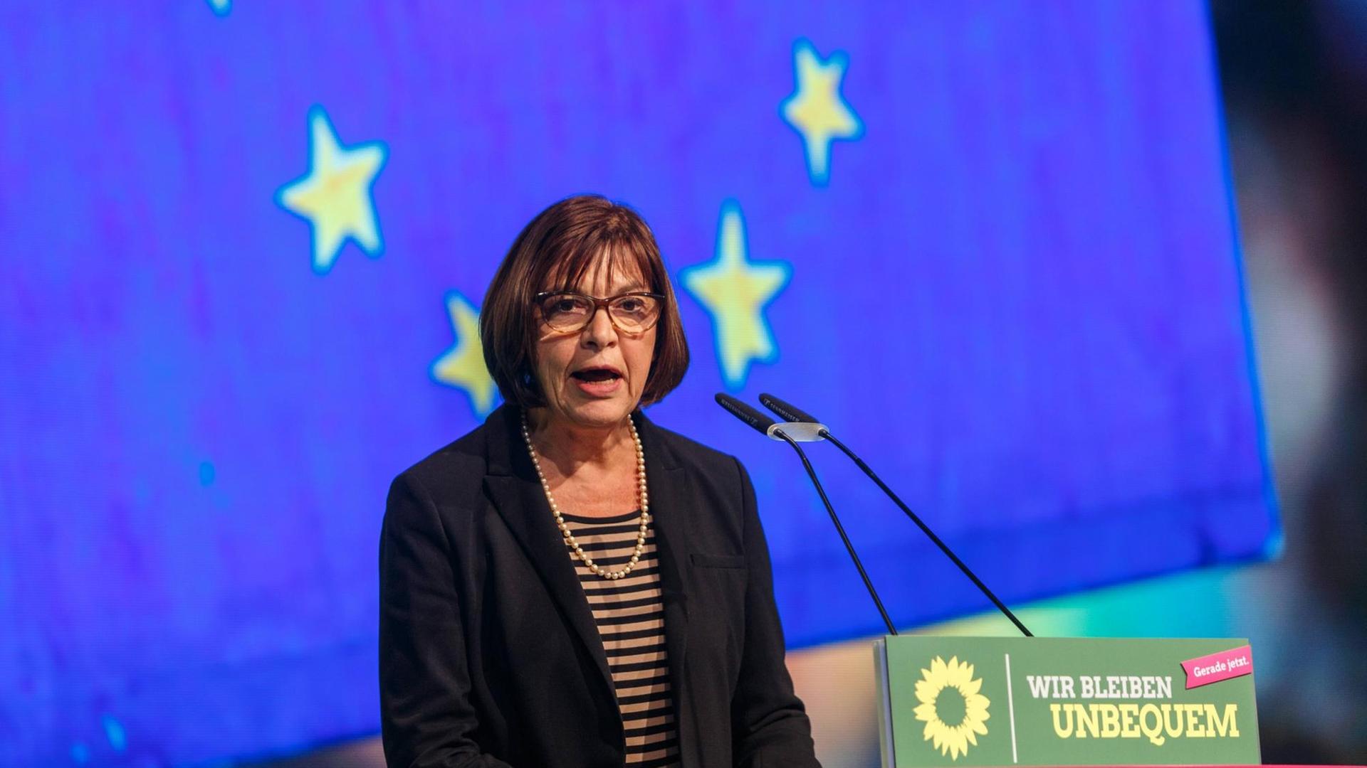 Rebecca Harms spricht auf einer Delegiertenkonferenz, im Hintergrund ist die Europafahne zu sehen