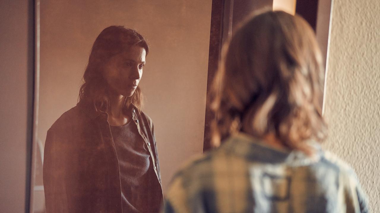 Szene aus der Serie "Unbroken". Alex (Aylin Tezel) steht mit leinem leeren Blick vor einem Spiegel.