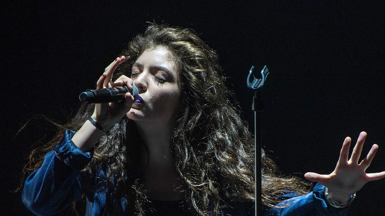 Die neuseeländische Sängerin Lorde singt in ein Mikrofon.