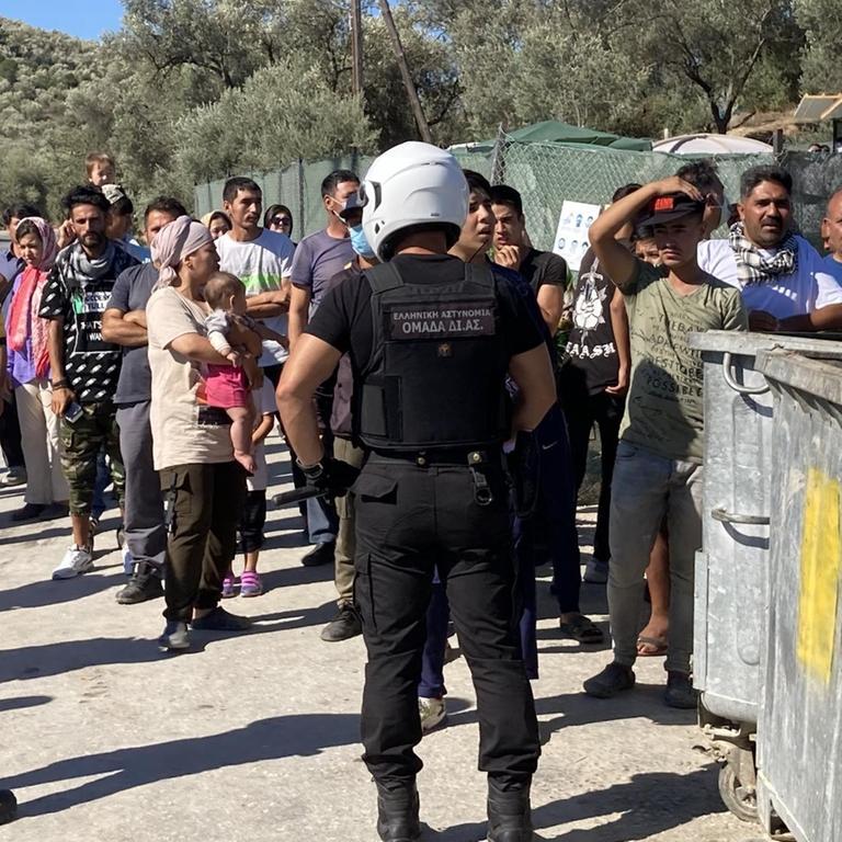 Sicherheitskräfte schirmen bei einem Besuch von Nordrhein-Westfalens Ministerpräsident Laschet und Integrationsminister Stamp im Flüchtlingslager Moria Flüchtlinge ab