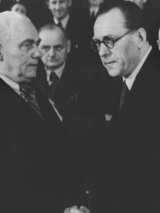 Symbolischer Händedruck zwischen Willhem Pieck, dem Vorsitzenden der KPD (l), und dem SPD-Vorsitzenden Otto Grotewohl (r) in der Berliner Staatsoper in der sowjetischen Besatzungszone im April 1946. Die beiden Parteien verschmolzen zur Sozialistischen Einheitspartei Deutschlands (SED).