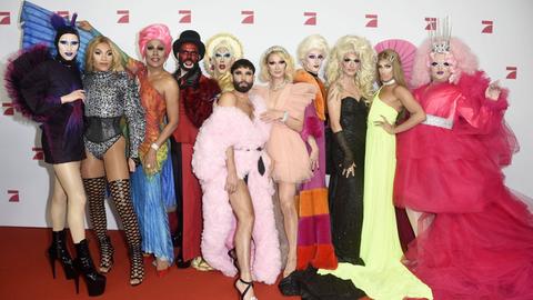 Eine Gruppe Dragqueens stehen auf dem Roten Teppich