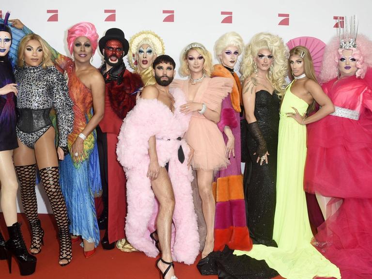 Eine Gruppe Dragqueens stehen auf dem Roten Teppich