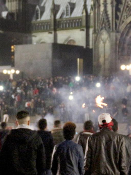 Menschengruppen in der Silvesternacht auf dem Vorplatz des Hauptbahnhofs in Köln.