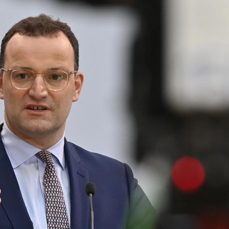 Der Gesundheitsminister wird in Berlin von einer Kamera aufgenommen.