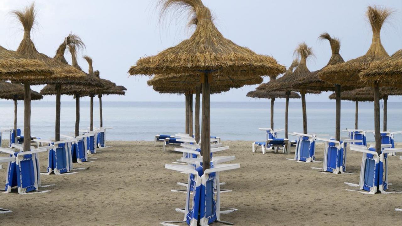 Sonnenschirme und Tische am Strand, Mallorca, Spanien