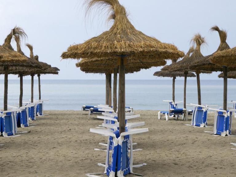 Sonnenschirme und Tische am Strand, Mallorca, Spanien