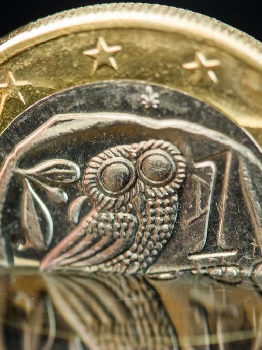 Eine griechische Euro-Münze spiegelt sich in einer Wasserfläche.