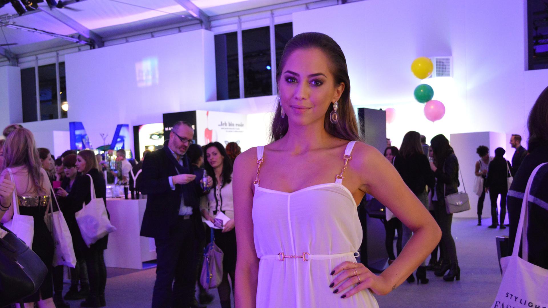 Die schwedische Bloggerin Kenza Zouiten steht in einem weißen Kleid auf der Berlin Fashion Week.