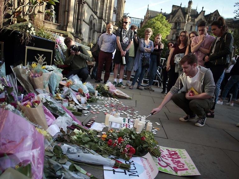 Menschen zünden Kerzen für die Opfer des Attentates in Manchester an.