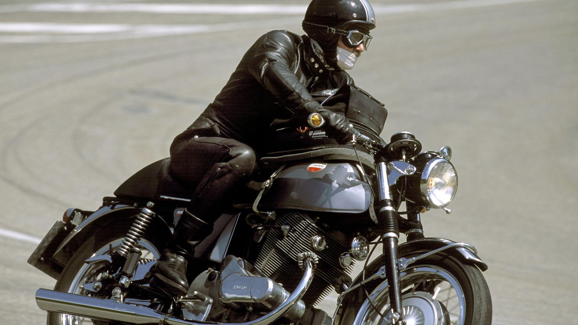 Auf dem Bild sieht man einen Motorradfahrer, der am Großen Feldberg in eine Kurve fährt. Das Motorrad ist eine restaurierte Laverda.