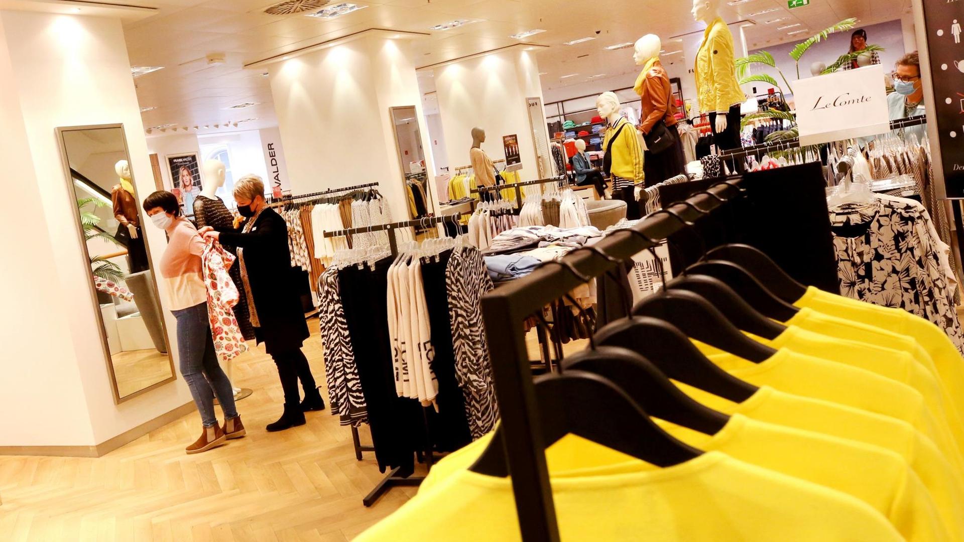 Nordrhein-Westfalen, Essen: Eine Mitarbeiterin der Modekette Sinn bedient in der Damenabteilung eine der ersten Kundinnen nach dem mehrwöchigen, coronabedingten Lockdown. Nordrhein-Westfalen, Essen: Eine Mitarbeiterin der Modekette Sinn bedient in der Damenabteilung eine der ersten Kundinnen nach dem mehrwöchigen, coronabedingten Lockdown.
