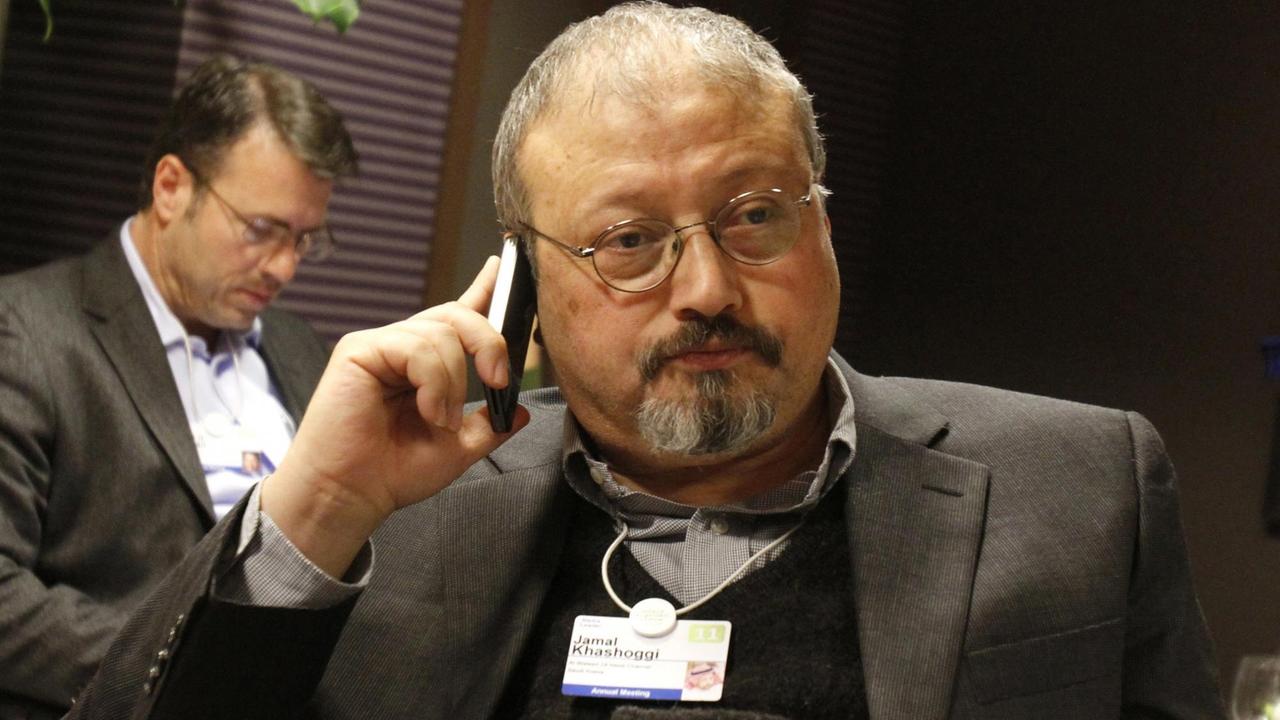 Der Journalist Jamal Khashoggi hält sich mit der rechten Hand ein Handy an das Ohr.