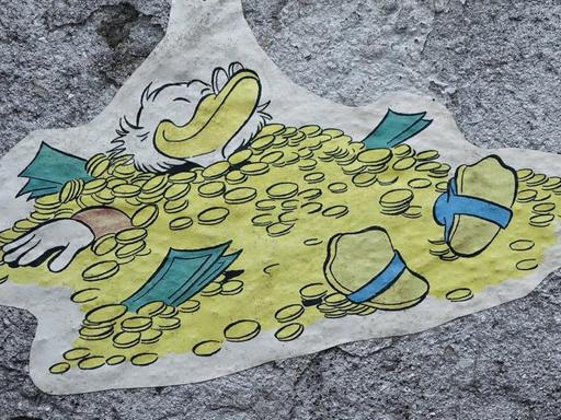 Streetart mit Dagobert Duck, der in Geld badet