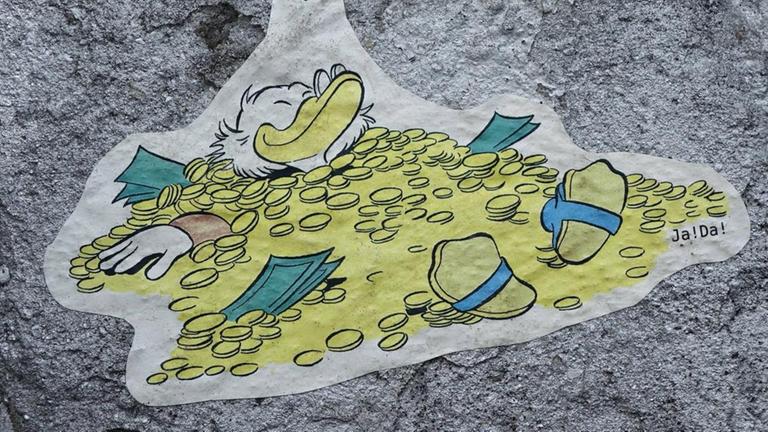 Streetart mit Dagobert Duck, der in Geld badet