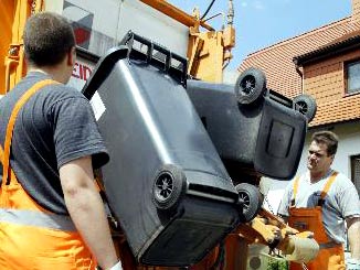 Mitarbeiter der Stadtwirtschaft Erfurt beladen ein Pressmüllfahrzeug