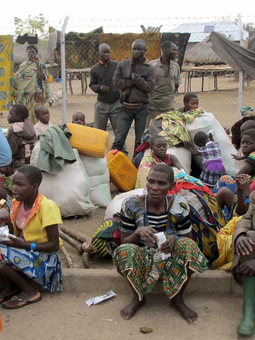 Aus dem Kongo kommende Flüchtlinge sitzen am 06.03.2018 im ugandischen Sebagoro auf dem Boden.