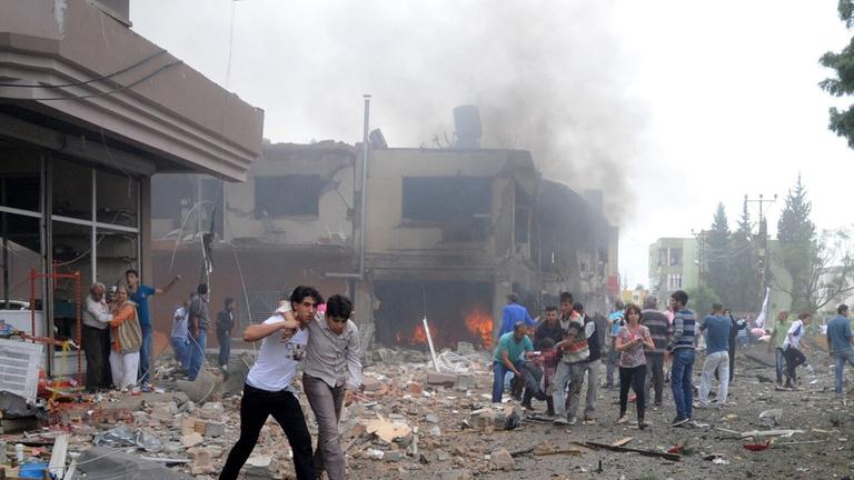 epa03695968 People help victims after an explosion in Reyhanli District, Hatay, Turkey 11 May 2013. At least 13 people were killed and 22 wounded following explosions on 11 May in southern Turkey near the Syrian border, Turkish television NTV reported. In epa03695968 People help victims after an explosion in Reyhanli District, Hatay, Turkey 11 May 2013. At least 13 people were killed and 22 wounded following explosions on 11 May in southern Turkey near the Syrian border, Turkish television NTV reported. In