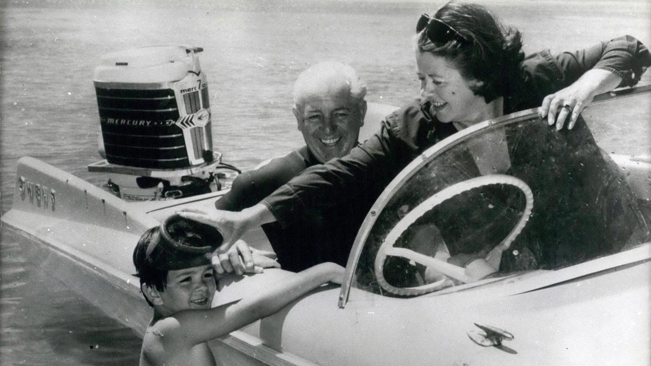 Schwarz-Weiß-Aufnahme des früheren australischen Premierministers Harold Holt mit seiner Frau und seinem Enkelsohn in einem Boot am Strand von Portsea in Australien