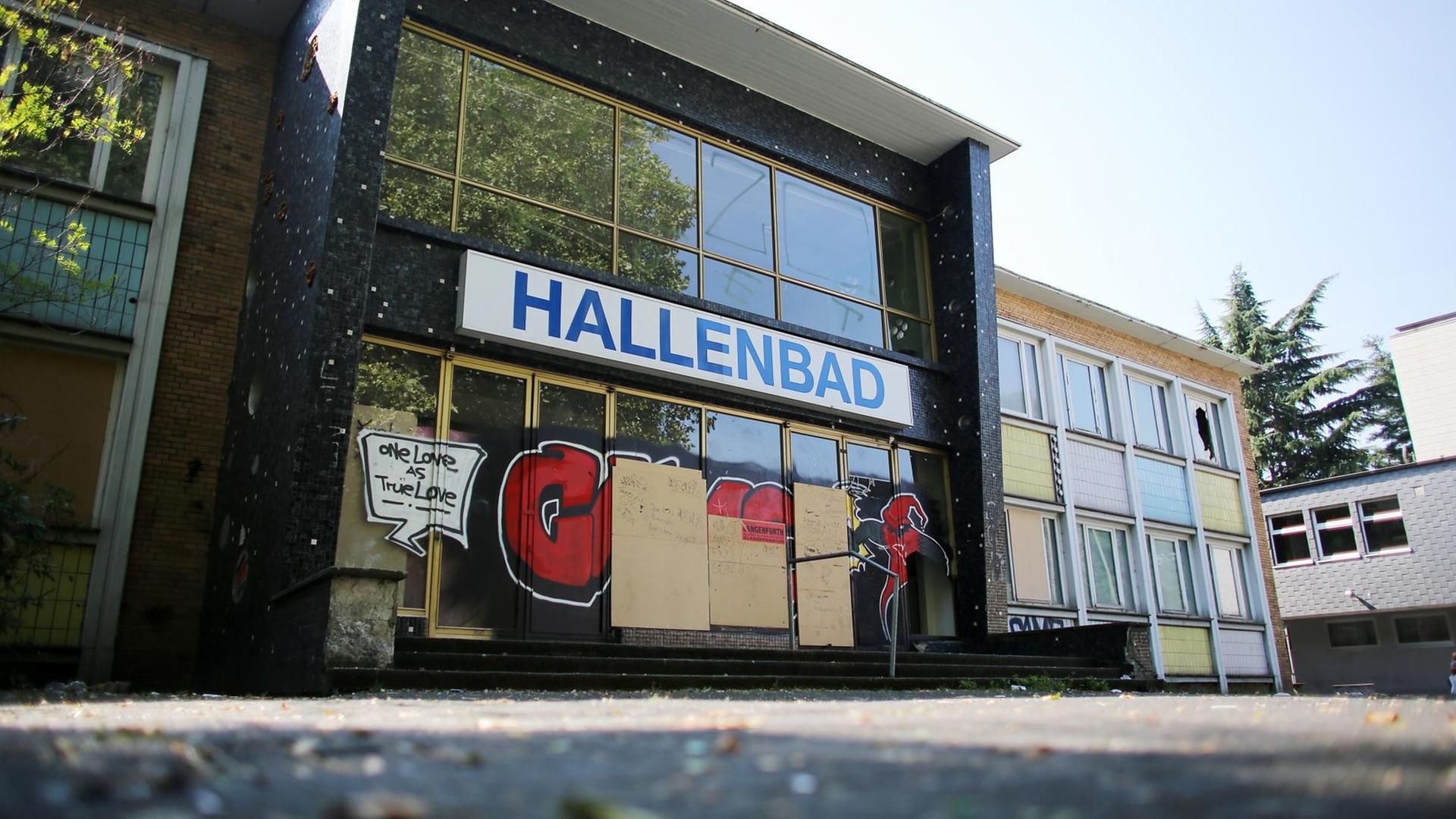 Die Eingangstüren eines geschlossenen Hallenbades in Duisburg ist mit Spanplatten verschlossen